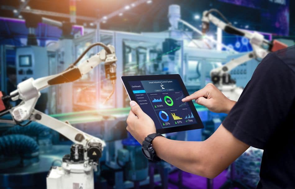 Smart industry control concept.Hands holding tablet on blurred automation machine as background