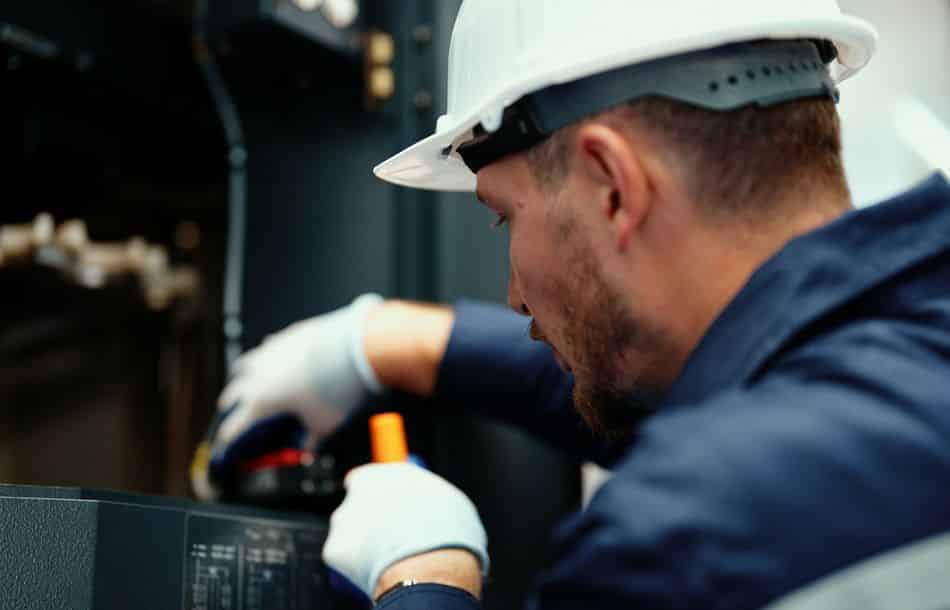 Close-up of Caucasian production engineer in safety wear inspect